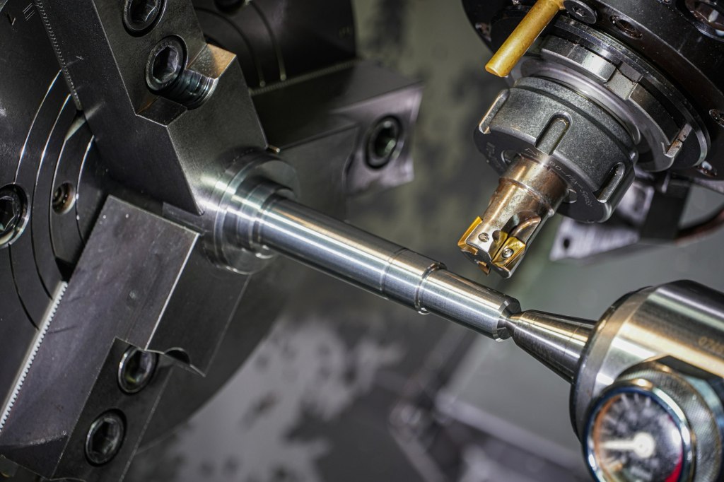 Steel bar being precision machined on a lathe