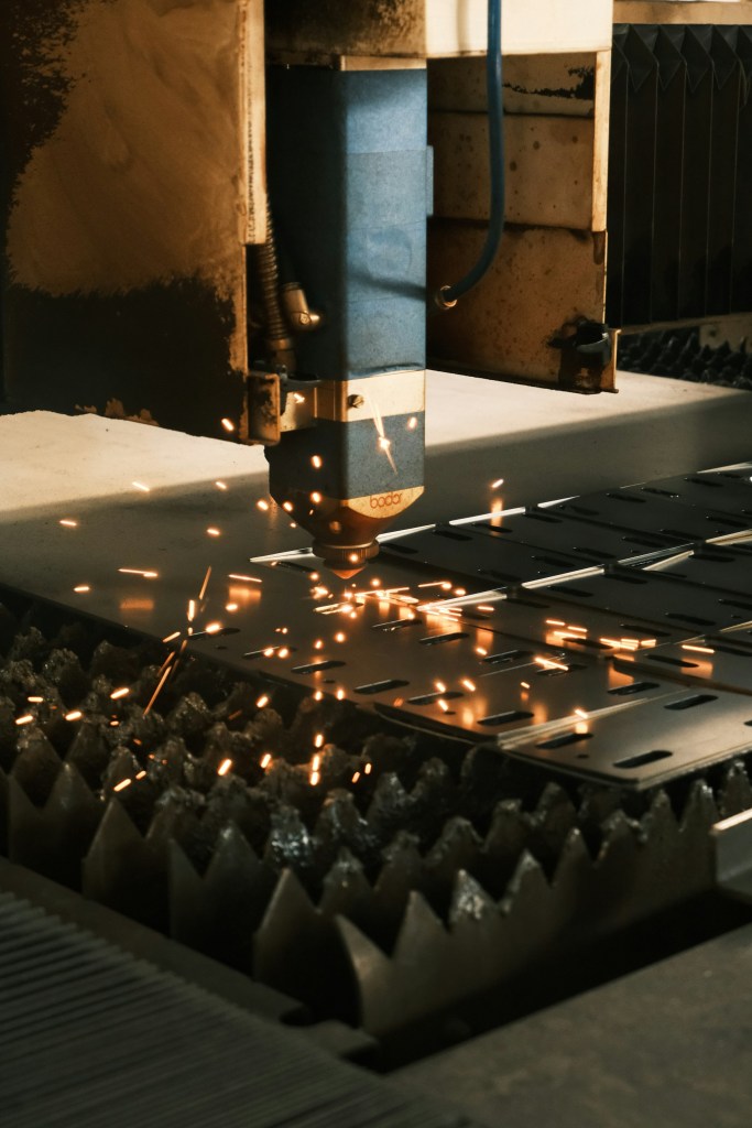 Machine cutting a piece of metal with sparks